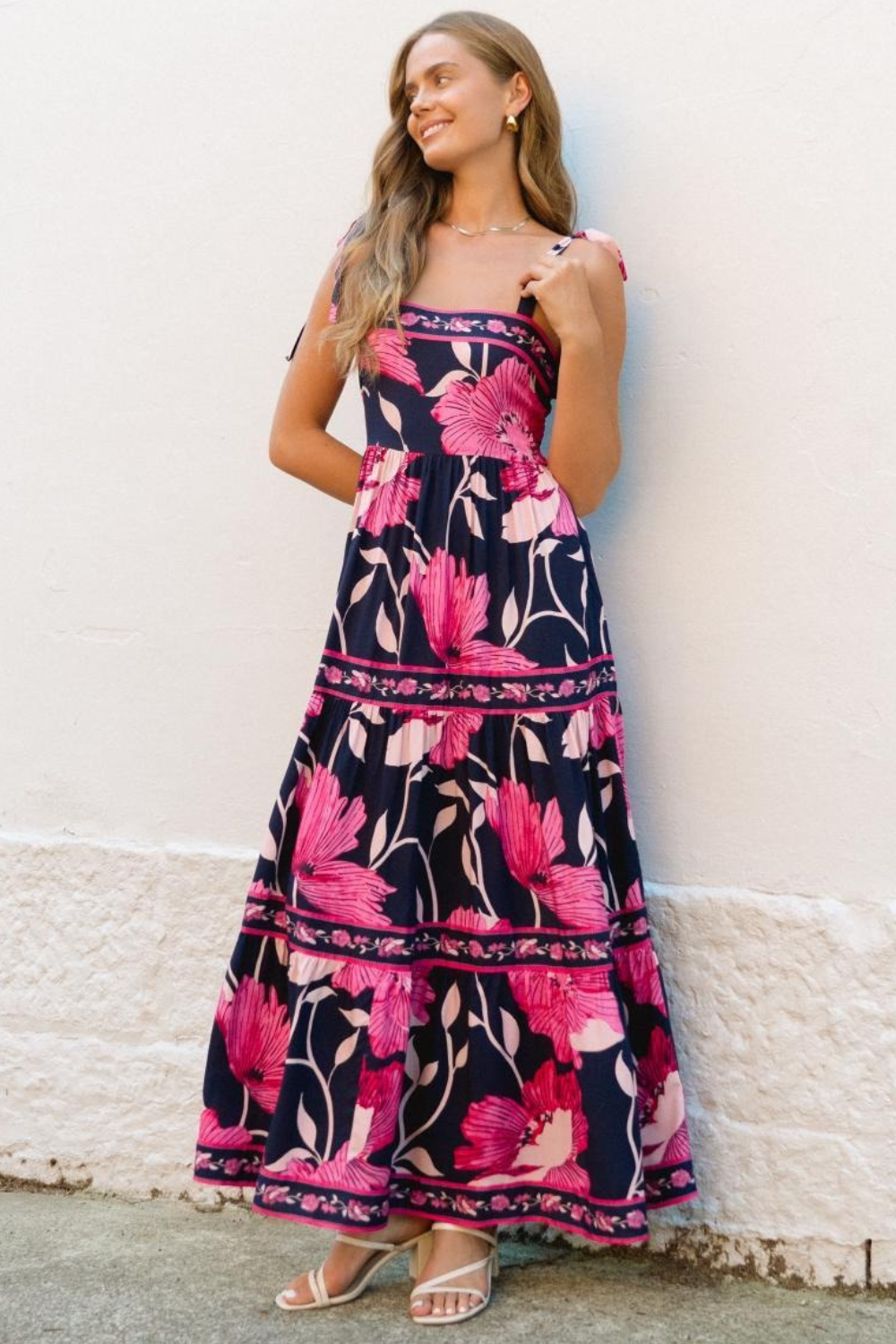 Woman wearing a floral dress against a white wall
