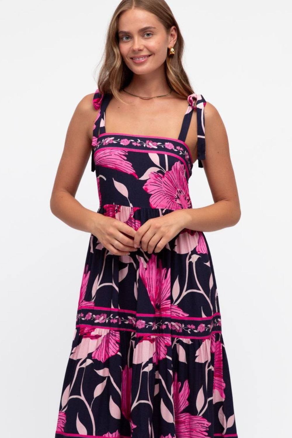 Woman wearing a floral dress with pink and purple flowers on a white background