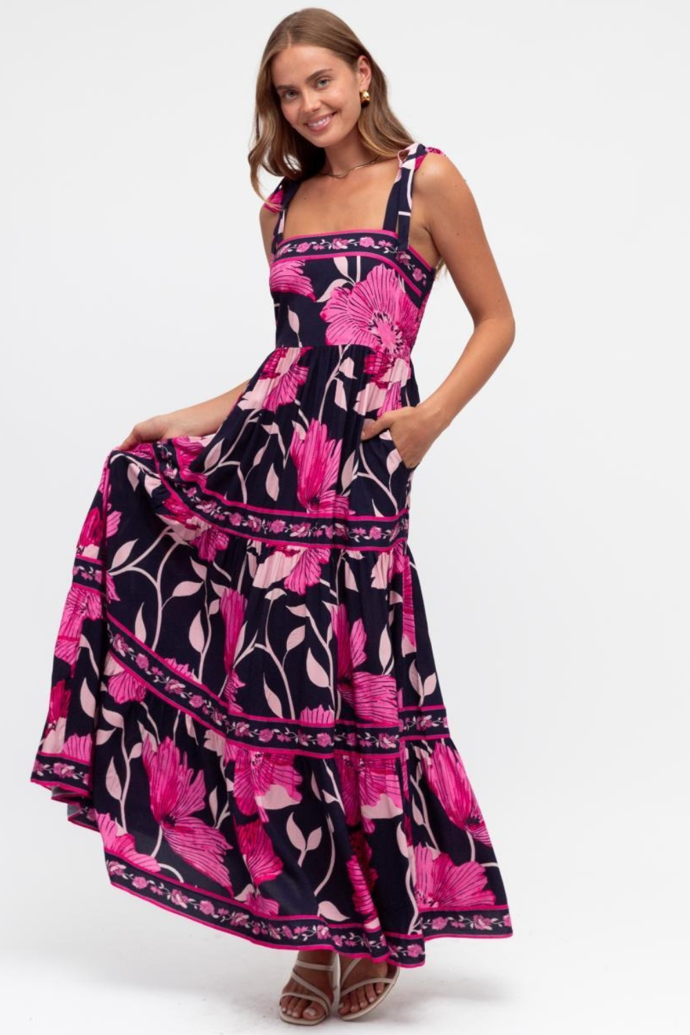 Woman wearing a pink and black floral dress on a white background