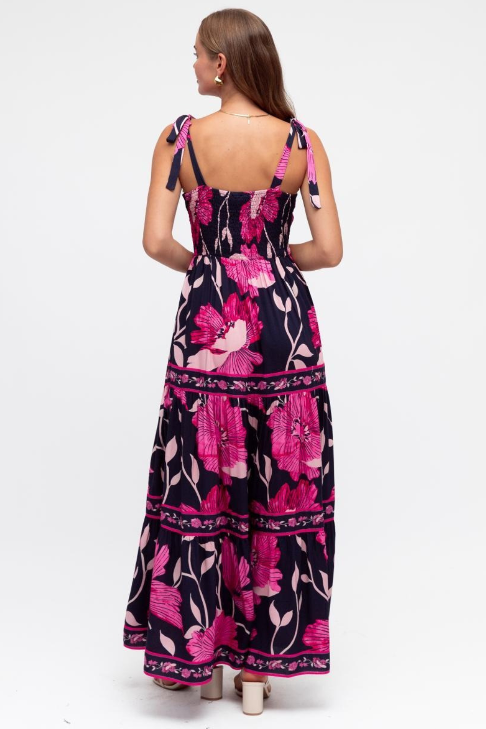 Woman wearing a floral dress with pink flowers on a white background