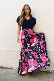 A model wearing a high-waisted, tiered maxi skirt with a midnight floral print, paired with a solid dark top.