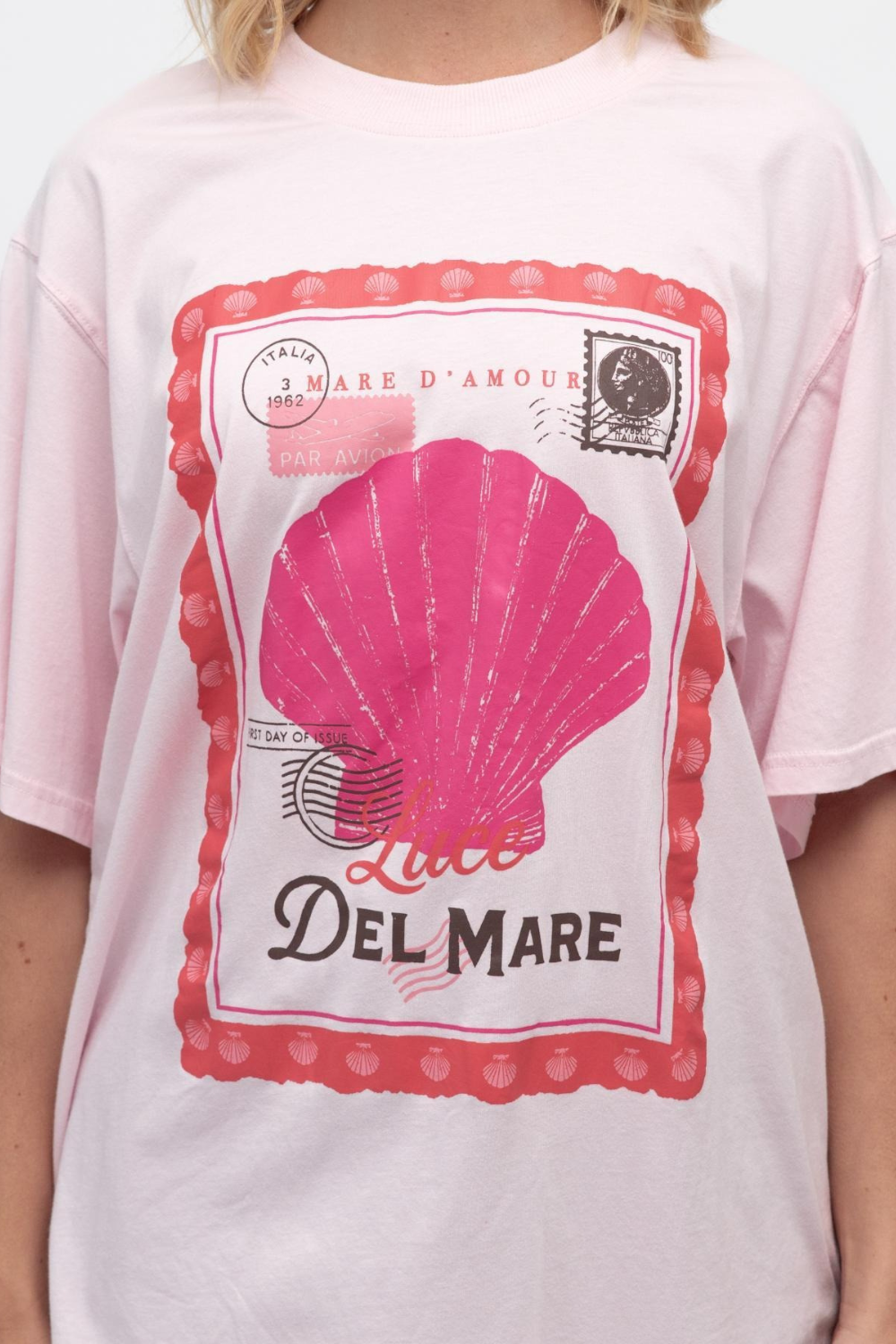 Pink t-shirt with a pink shell graphic and 'Del Mare' text on a white background