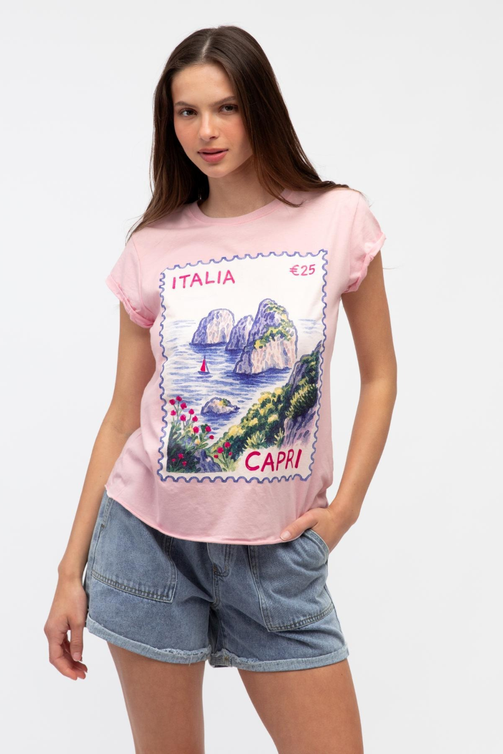 Woman wearing a pink t-shirt with a Capri stamp design on a white background