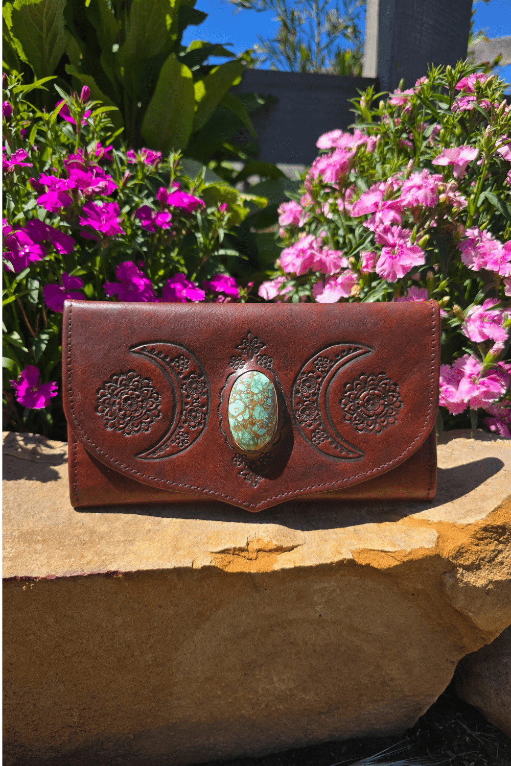 Dark Brown Antique style leather wallet with hand tooled crescent moons and flowers surrounding a stone.