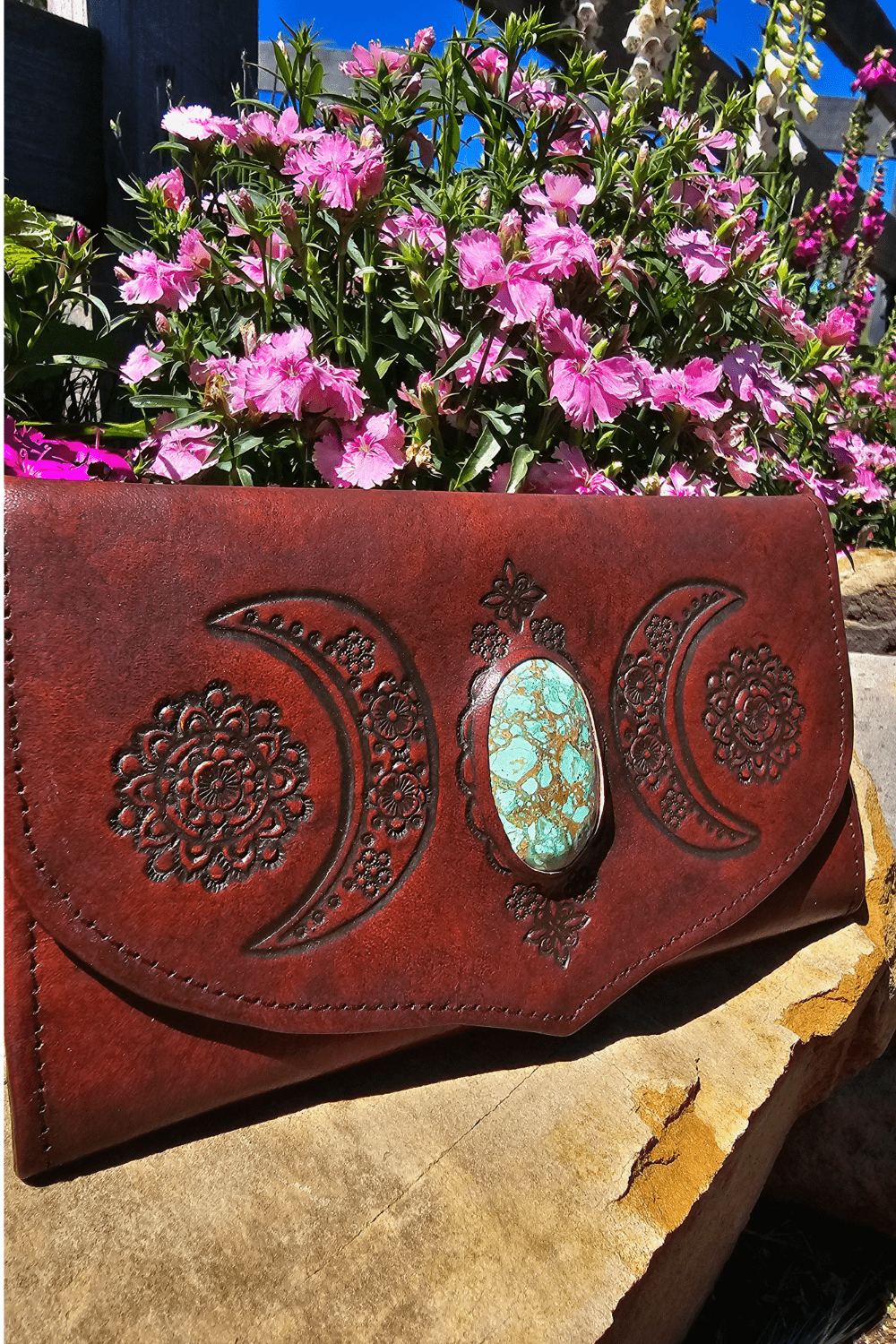 Dark Brown Antique style leather wallet with hand tooled crescent moons and flowers surrounding a stone.