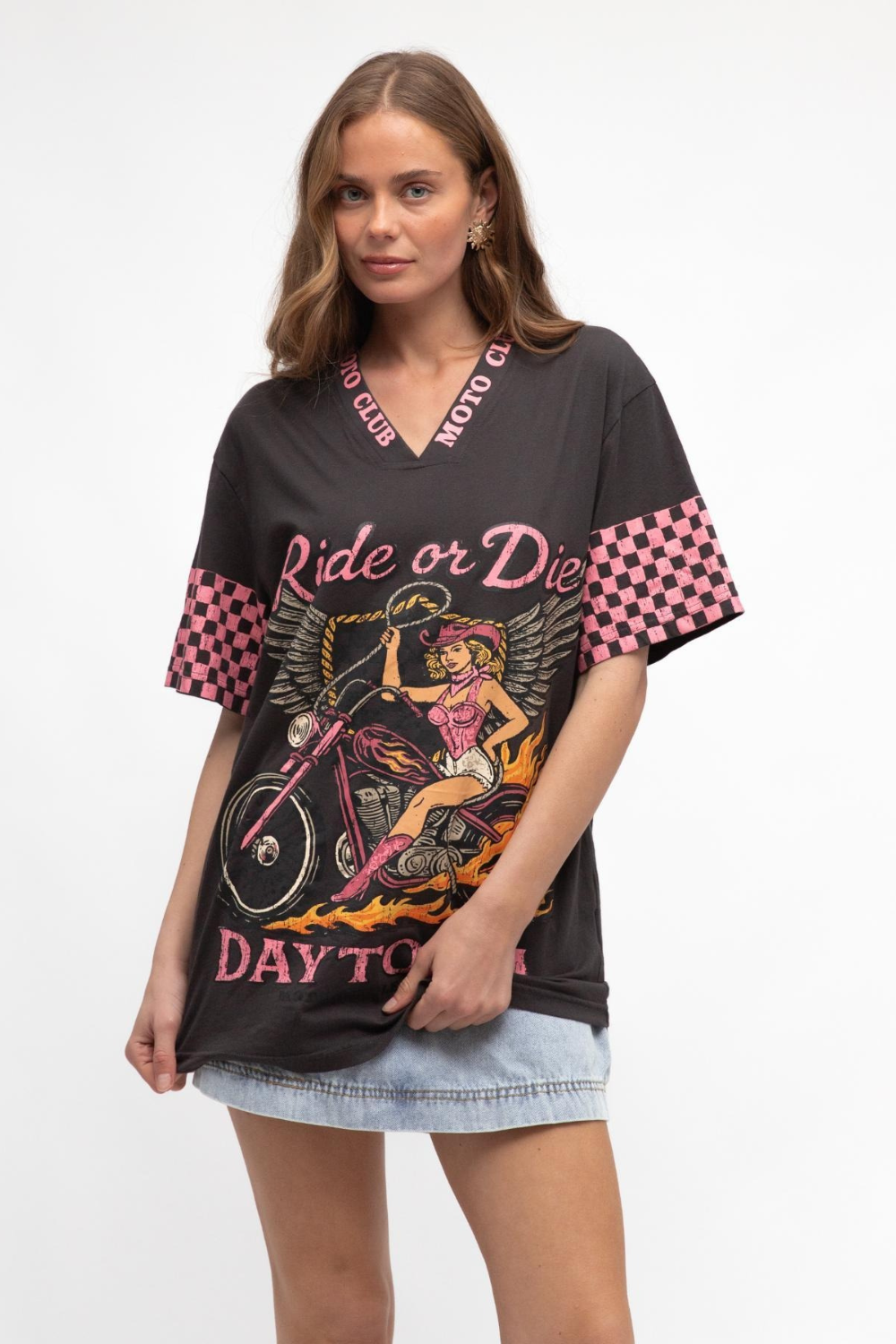 Woman wearing a black graphic t-shirt with pink and red design elements on a white background