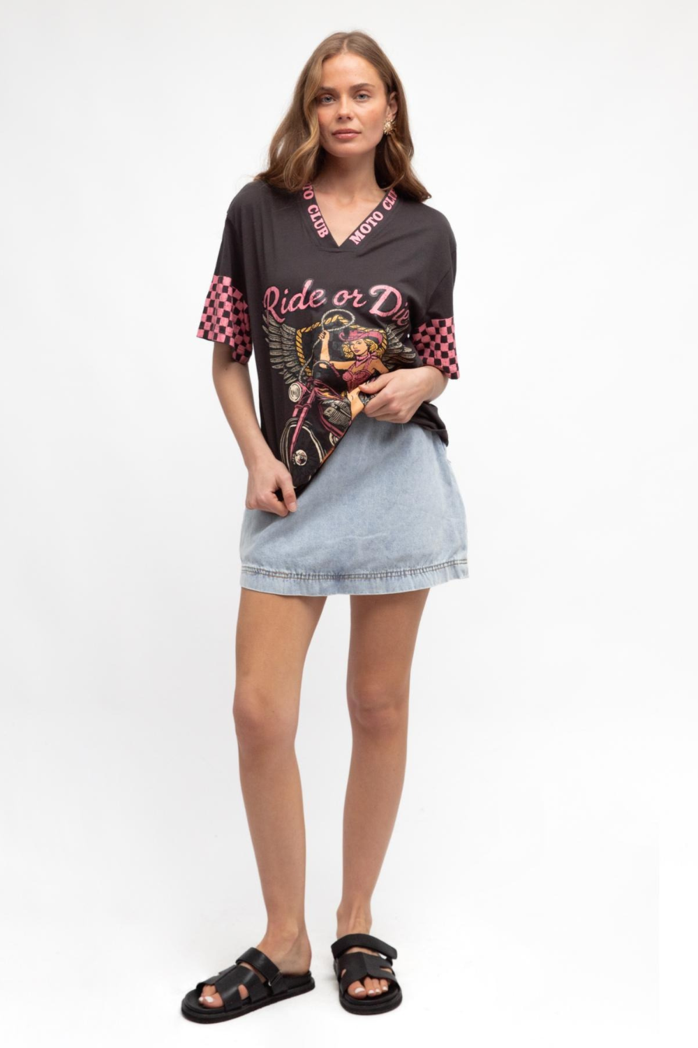 Woman wearing a graphic t-shirt and denim shorts on a white background