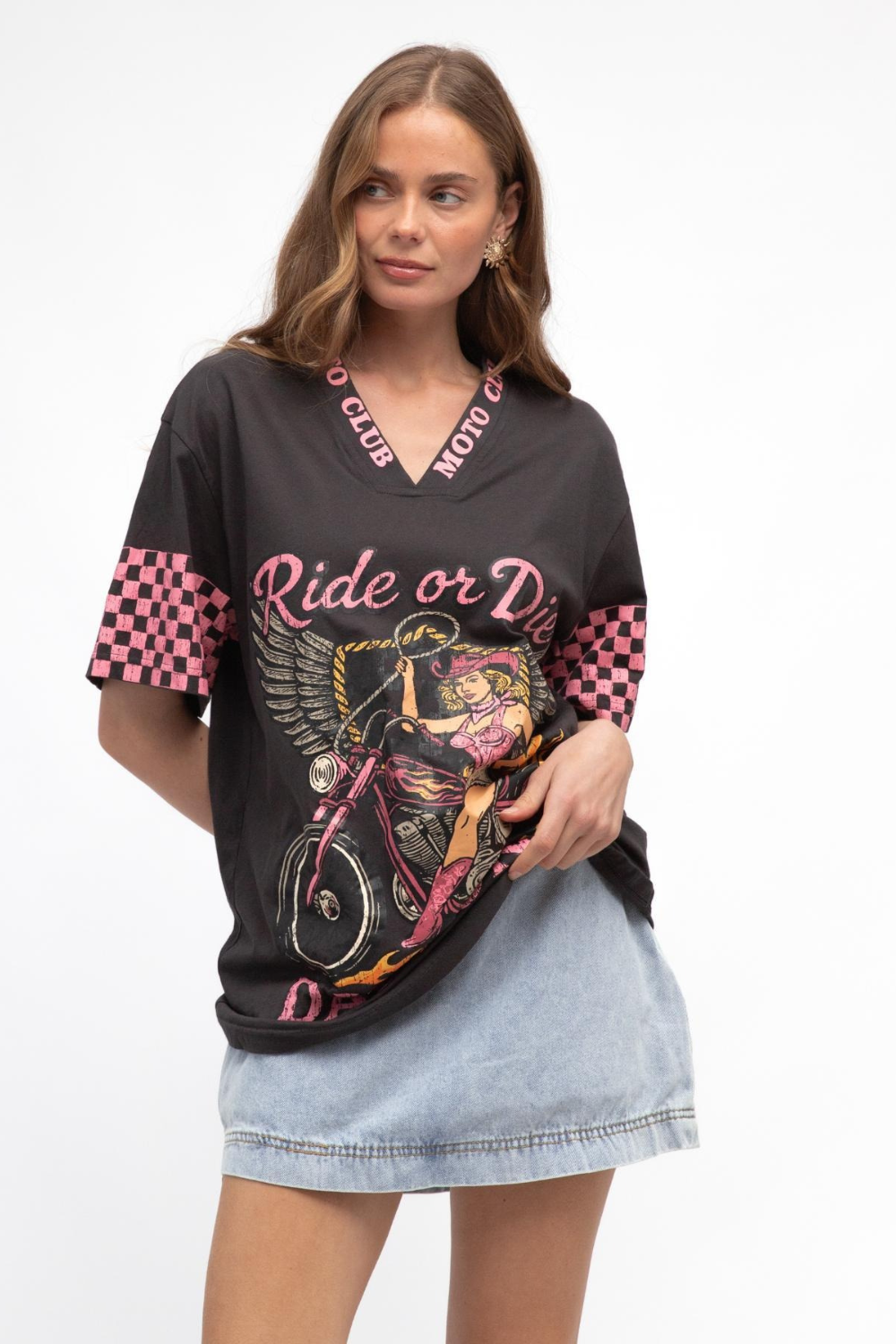 Woman wearing a black graphic t-shirt with pink and red text and designs on a white background