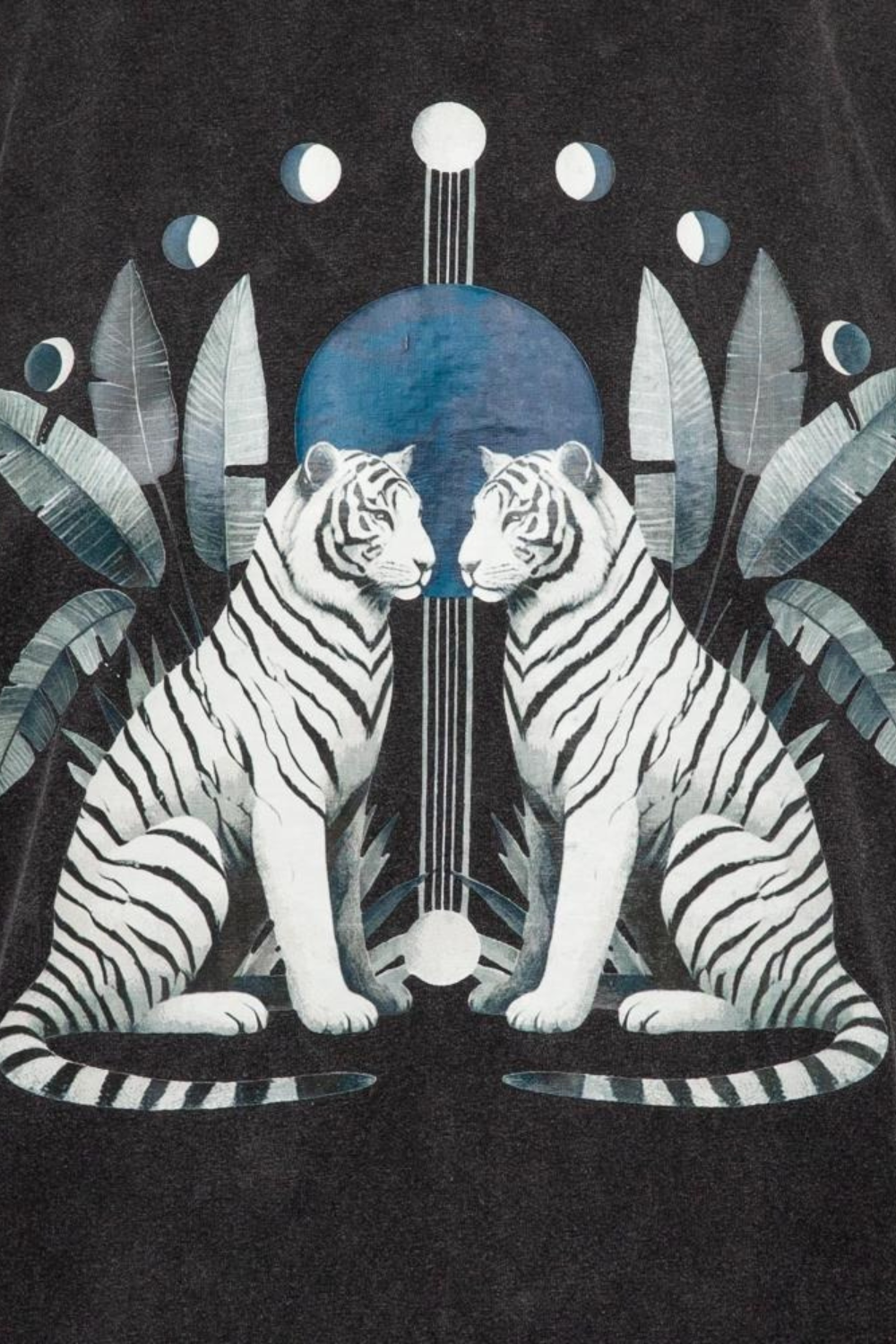 Two white tigers sitting side by side with a blue moon and leaves in the background on a black shirt.